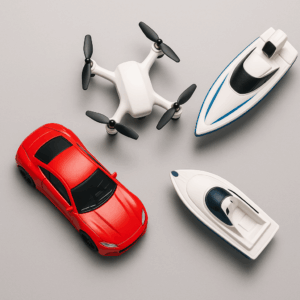 Red toy car, white drone, and white speedboat arranged on a gray background